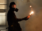 A protester holds a petrol bomb during clashes with riot police after a demonstration against new austerity measures outside the parliament in Athens, Greece, on Nov. 7. A protester holds a petrol bomb during clashes with riot police after a demonstration against new austerity measures outside the parliament in Athens, Greece, on Nov. 7.
