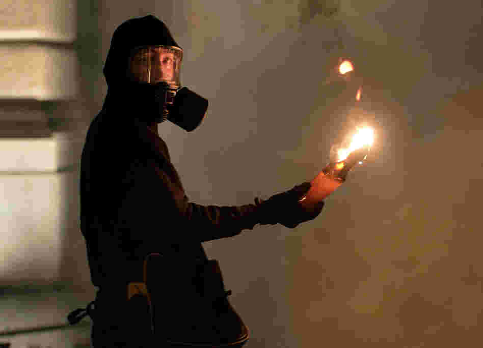 A protester holds a petrol bomb during clashes with riot police after a demonstration against new austerity measures outside the parliament in Athens, Greece, on Nov. 7.
