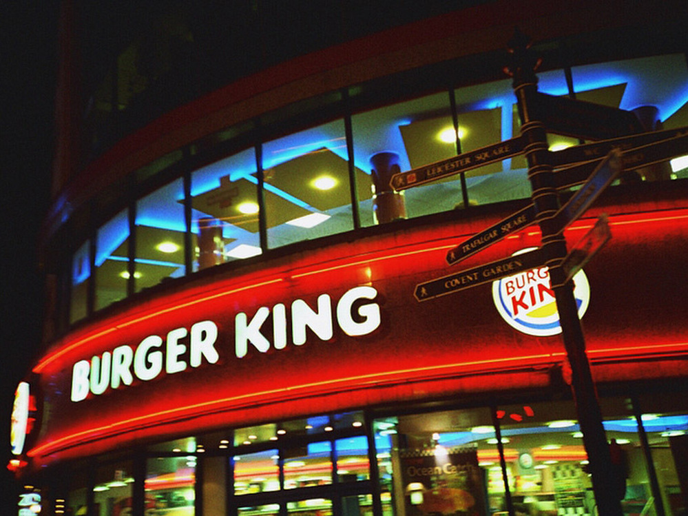 Signs point to tourist destinations outside a Burger King in London.