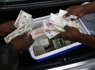Zimbabwean foreign currency dealers conduct a transaction from the trunk of a car using money stashed in a cooler box in Harare. Zimbabwean foreign currency dealers conduct a transaction from the trunk of a car using money stashed in a cooler box in Harare.