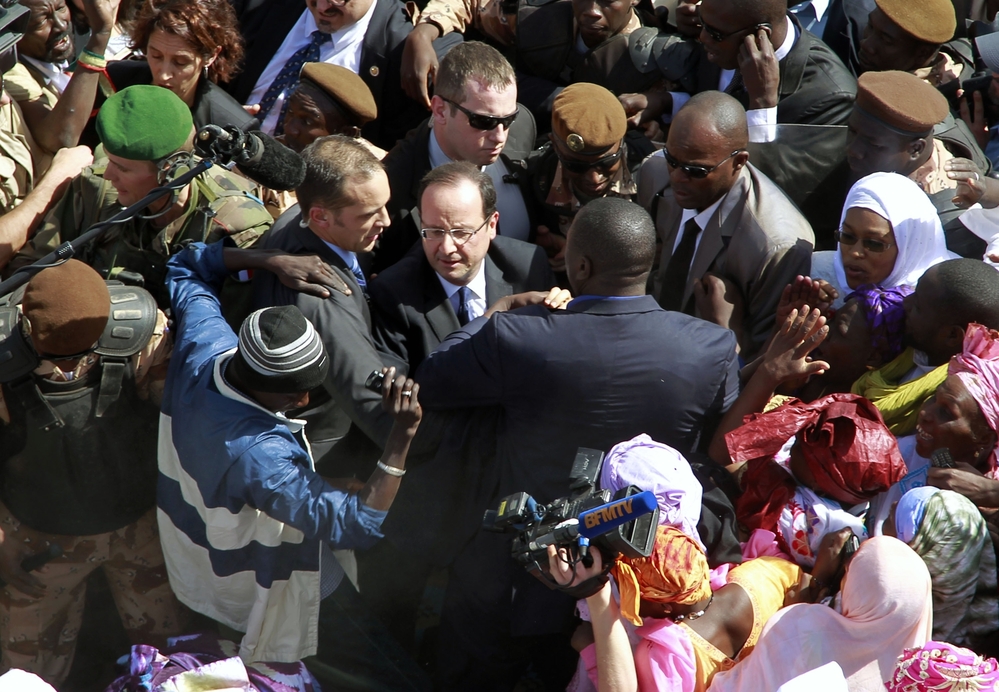 French President Francois Hollande is surrounded by well-wishers on his short visit to Timbuktu, Mali, on Saturday.