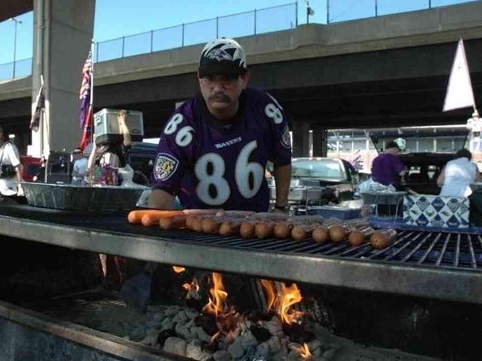 Ravens fan Michael Neapolitan at the grill after he's burned the opposing team's football cards.
