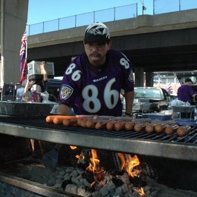 Ravens fan Michael Neapolitan at the grill after he's burned the opposing team's football cards.