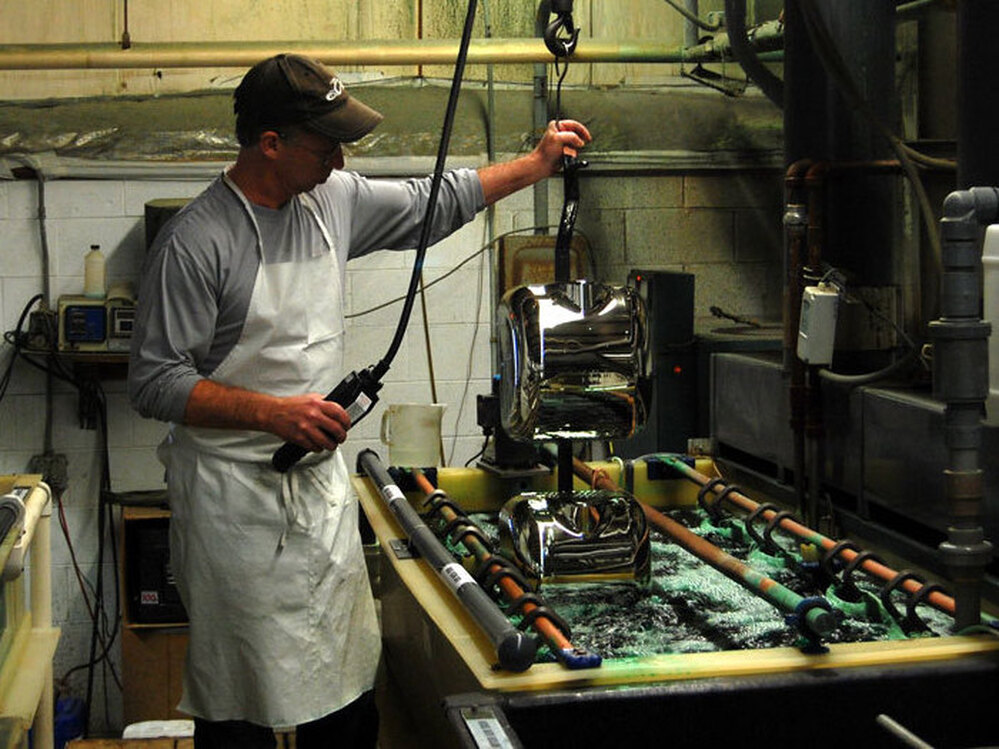 Craig McCarl dips Xlerator covers two at a time into a chrome bath. He has worked for Excel Dryer in East Longmeadow, Mass., for 31 years.