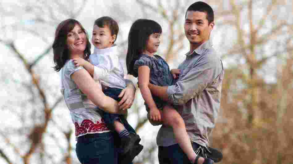 Jeannine Sato holds her 2-year-old son, Keni; 5-year-old Hana is held by her father, Mas Sato. Jeannine decided to leave her job when her employers said she could take six weeks off after giving birth to her first child or risk losing her job.