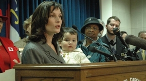 Sato holds Hana as she speaks during a 2009 press conference at the North Carolina state Legislature about the need for paid sick days.
