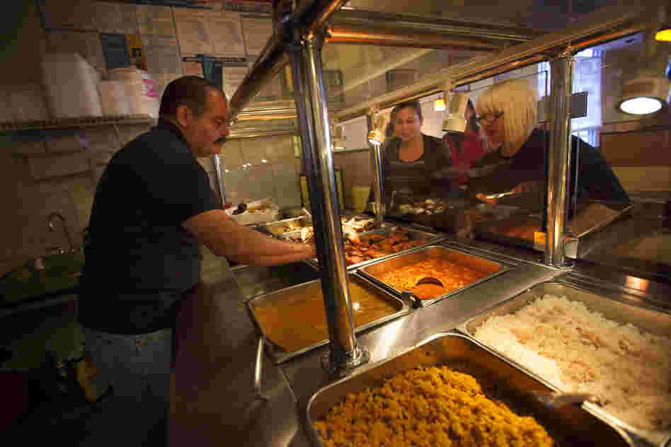 Miguel Fontanez Sr., the owner and founder of Pioco's Chicken in Kissimmee, Fla., serves customers at his restaurant. He opened the restaurant 11 years ago, and it has become a hub for the area's large Puerto Rican community.