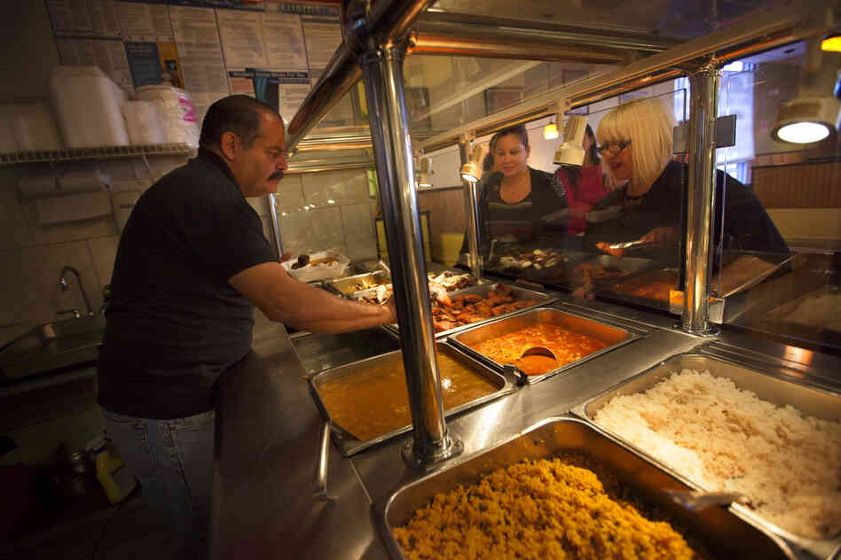Miguel Fontanez Sr., the owner and founder of Pioco's Chicken in Kissimmee, Fla., serves customers at his restaurant. He opened the restaurant 11 years ago, and it has become a hub for the area's large Puerto Rican community.