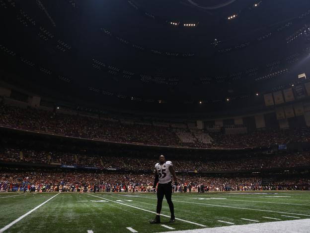 Baltimore Ravens linebacker Terrell Suggs waits on the field after the half the lights went out in the third quarter of Sunday's Super Bowl  against the San Francisco 49ers in New Orleans.