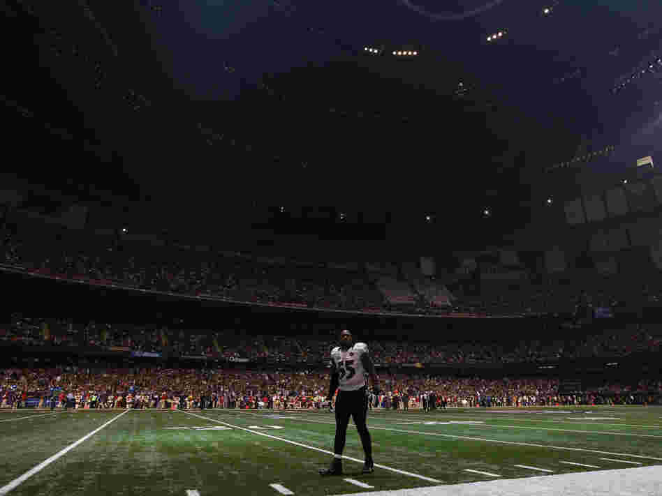Baltimore Ravens linebacker Terrell Suggs waits on the field after the half the lights went out in the third quarter of Sunday's Super Bowl  against the San Francisco 49ers in New Orleans.