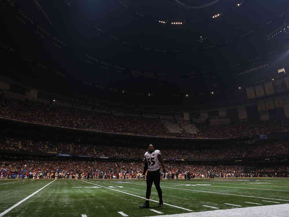 Baltimore Ravens linebacker Terrell Suggs waits on the field after the half the lights went out in the third quarter of Sunday's Super Bowl  against the San Francisco 49ers in New Orleans.