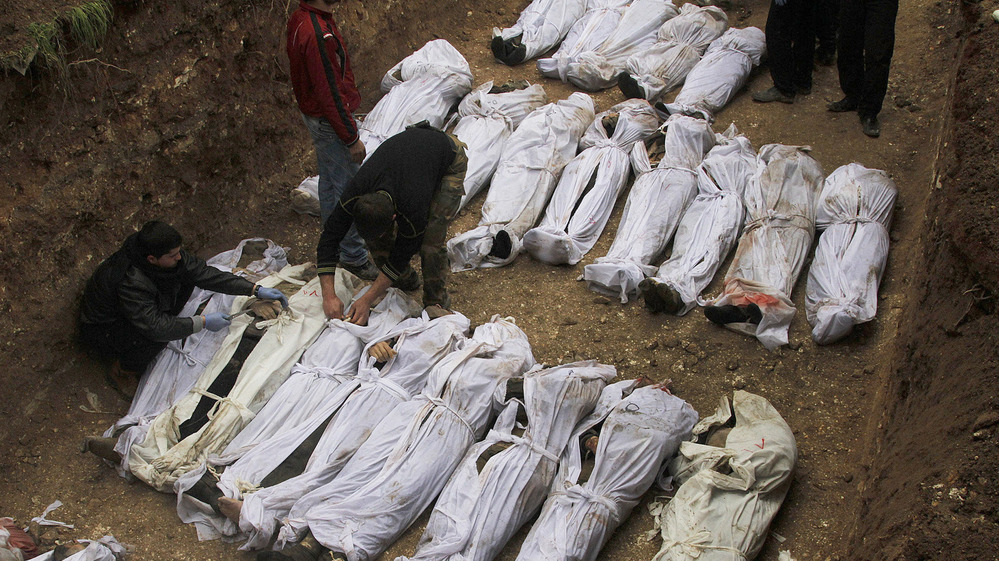 Syrian citizens bury those who were found dead next to a river last week, many of them with their hands bound behind their backs, in Aleppo, Syria, on Jan. 31.