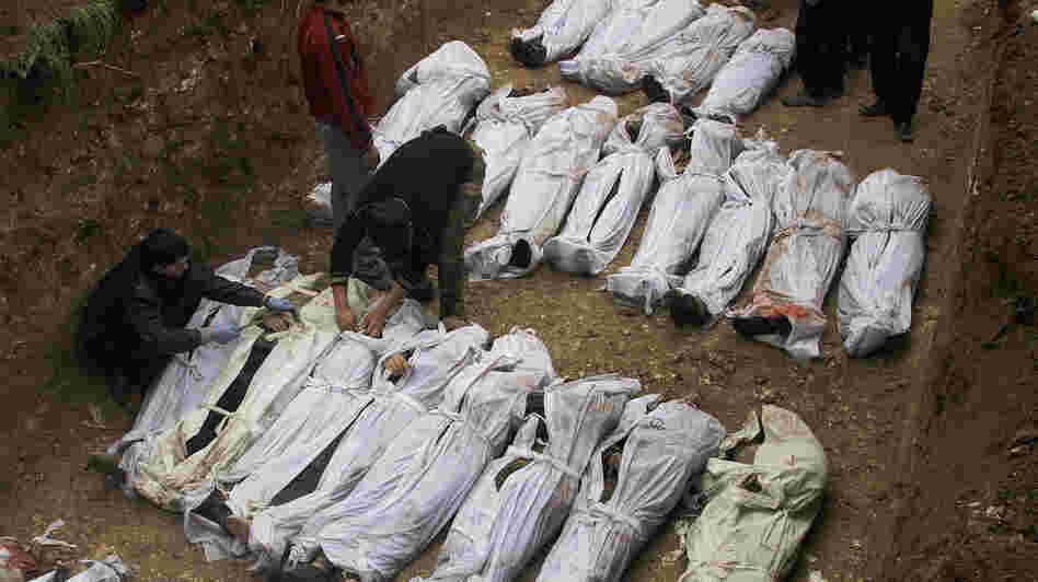 Syrian citizens bury those who were found dead next to a river last week, many of them with their hands bound behind their backs, in Aleppo, Syria, on Jan. 31.