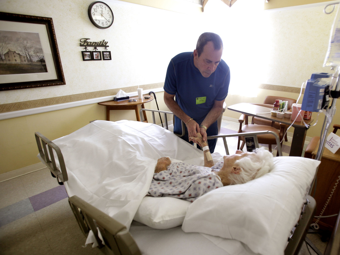 Joe Takach comforts his friend Lillian Landry, as she spends her last days in the hospice wing of a hospital in Oakland Park, Fla., in 2009.