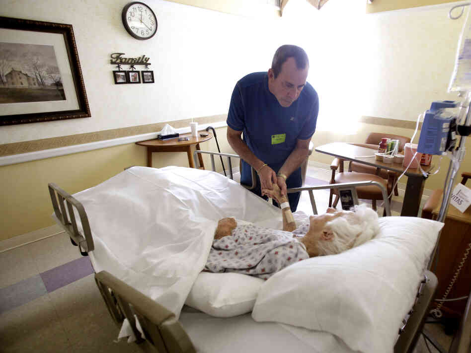 Joe Takach comforts his friend Lillian Landry, as she spends her last days in the hospice wing of a hospital in Oakland Park, Fla., in 2009.