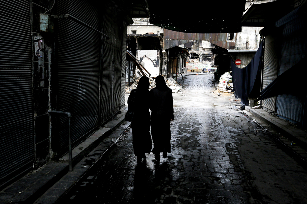 Syrian women walk through a market area in the northern city of Aleppo last November. A new website is documenting the use of rape in the Syrian conflict.
