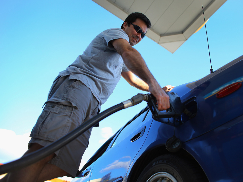 Raul Rivero fills up in Miami. Having less take-home pay at the same time gas prices are rising could dampen consumer spending, economists say.