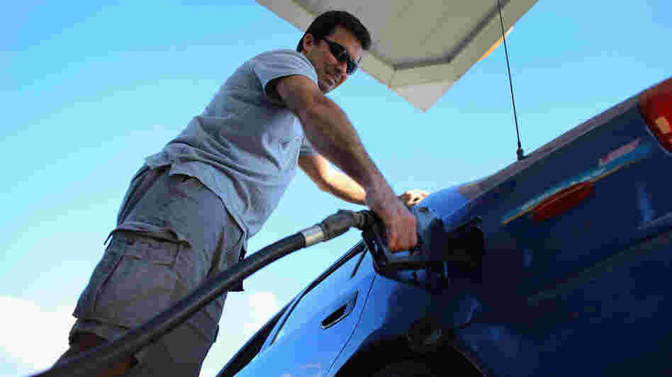 Raul Rivero fills up in Miami. Having less take-home pay at the same time gas prices are rising could dampen consumer spending, economists say.