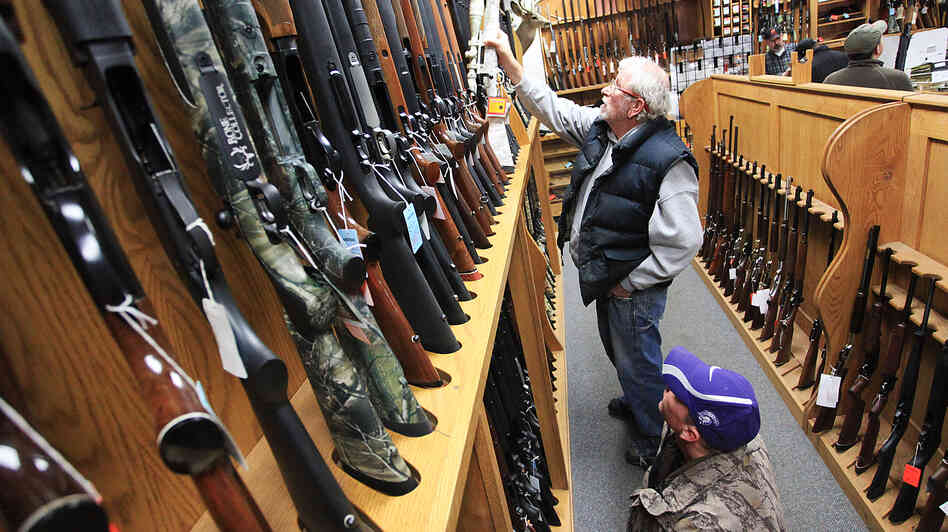 Jeff Torgerson (top) and Dan Volkman browse the selection of rifles at Mainstream Firearms and Marine in Winona, Minn., on Monday.