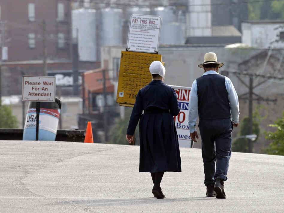 An Amish man and woman walk through a parking lot after leaving the U.S. courthouse in Cleveland in September. Sixteen members of an Amish group in Bergholz, Ohio, led by Samuel Mullet, were found guilty of attacks targeting Amish bishops.