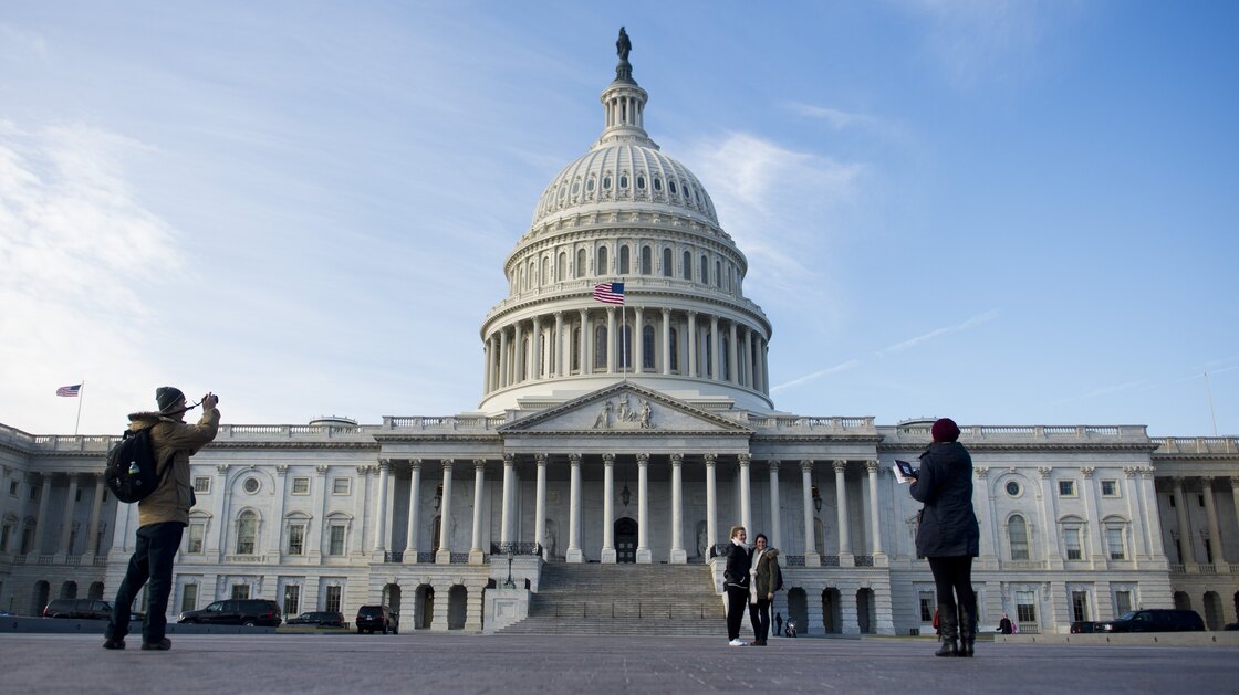 Tourists take photographs in front of the U.S. Capitol on Jan. 2, the day after Congress passed a bill to avoid the fiscal cliff.
