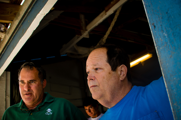 Day Boat Seafood co-owners Scott Taylor (left) and Howard Bubis watch workers unload thousands of pounds of catch from a long-line boat that was out for 10 days at their boathouse in Fort Pierce, Fla.
