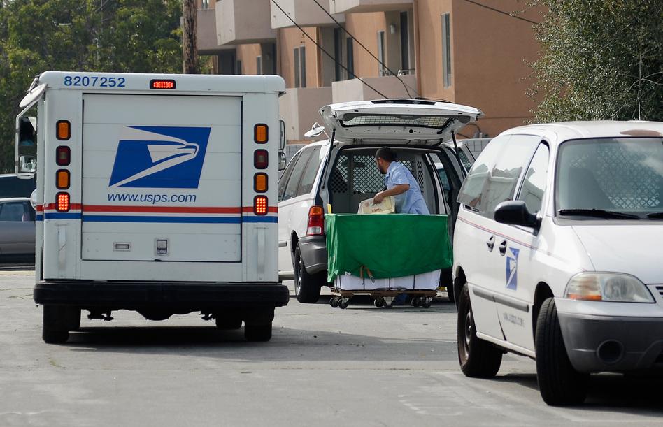 A U.S. Postal service employee loads his van as he prepares to leave the loading dock to deliver mail from the Los Feliz Post Office in Los Angeles.