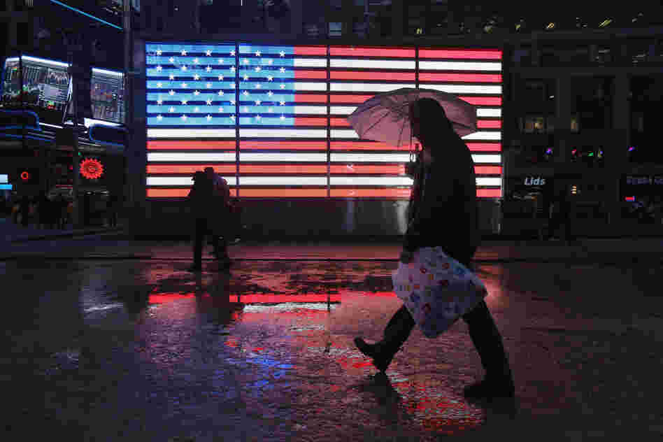People walk through Times Square as a major winter storm moves in on Friday in New York City. Snow and freezing rain fell over Midtown Manhattan as the city braced for the major storm. 