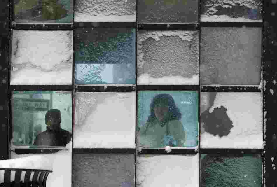 Riders wait in a bus stop where color-tinted windows collect snow during a storm in Portland, Maine. The storm sweeping into Maine already has dumped half a foot of snow around Portland, and contributed to a 19-car pileup.