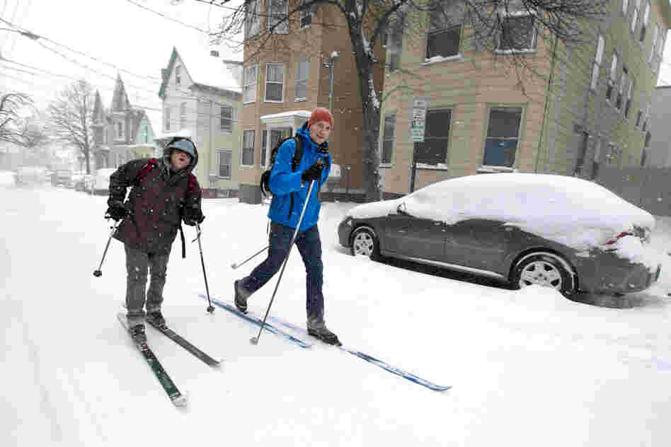Andre Tranchemantague (left) and Will Guerette ski to a bar during the early stages of the snowstorm in Portland.