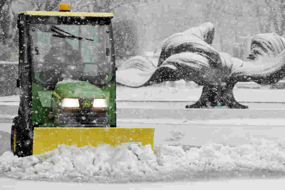 Kevin Quick plows a slushy mix in front of a bank during the storm in Buffalo, N.Y. In some parts of upstate New York, snow fell early Friday morning and was expected to increase throughout the day, with the heaviest accumulations expected in eastern New York on Friday night.