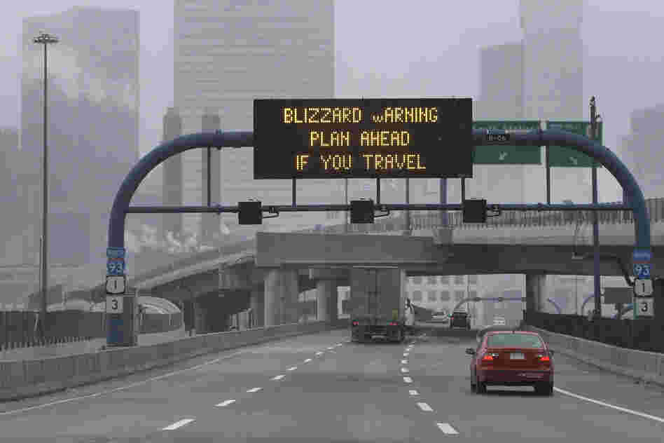 A warning sign flashes for motorists on the expressway into Boston as snow starts to fall on Friday.