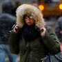 Trying to stay warm, a woman in New York City hung on to her hood Friday. Trying to stay warm, a woman in New York City hung on to her hood Friday.