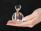 Woman holding vintage perfume bottle in her hand Woman holding vintage perfume bottle in her hand