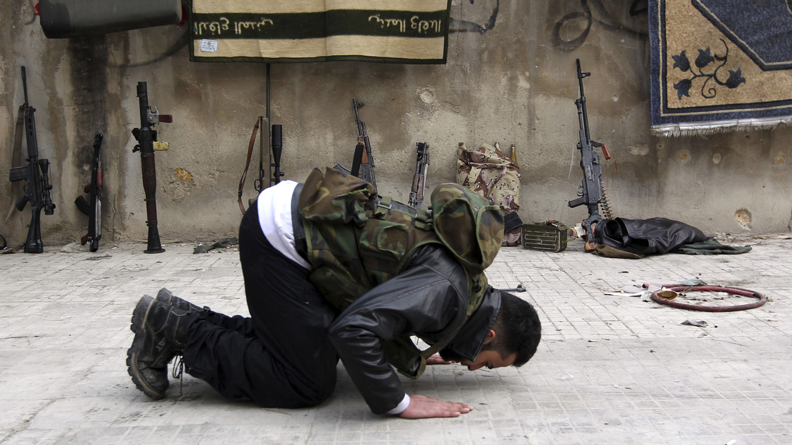 A Syrian rebel prays on a street in the northern city of Aleppo in January. Many Syrians are debating what role Islam should play in Syria if the current secular government is toppled.