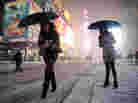 Two women look for a taxi in New York's Times Square on Friday.
