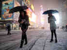 Two women look for a taxi in New York's Times Square on Friday.