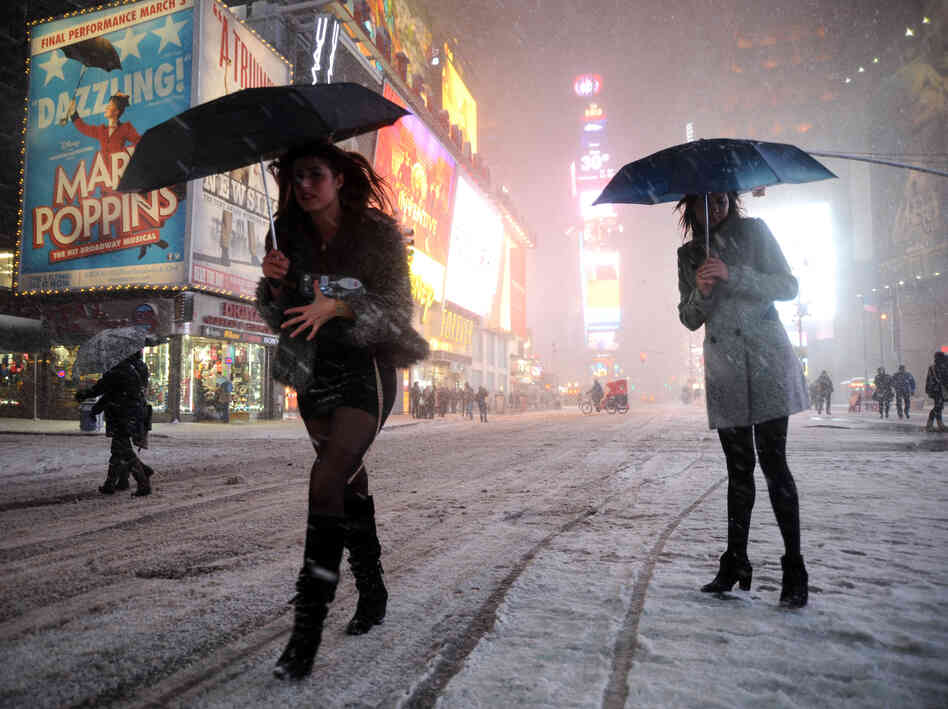 Two women look for a taxi in New York's Times Square on Friday.