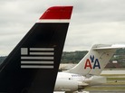 A US Airways plane rests near two American Airlines jets at Ronald Reagan Washington National Airport last year. The combined carrier would be named American Airlines. A US Airways plane rests near two American Airlines jets at Ronald Reagan Washington National Airport last year. The combined carrier would be named American Airlines.