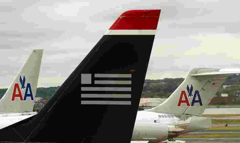 A US Airways plane rests near two American Airlines jets at Ronald Reagan Washington National Airport last year. The combined carrier would be named American Airlines.