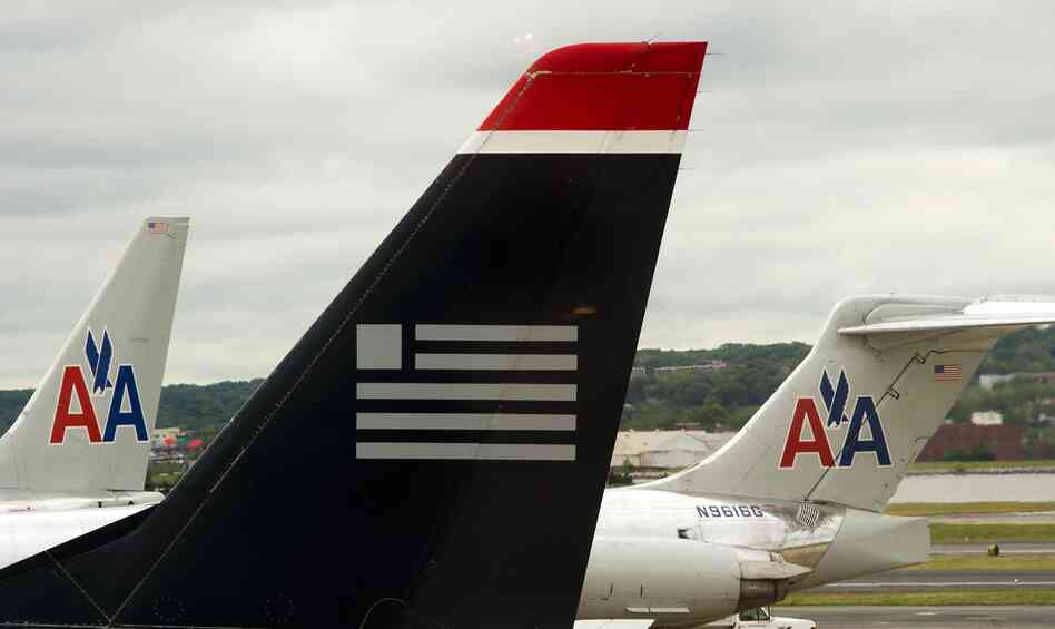 A US Airways plane rests near two American Airlines jets at Ronald Reagan Washington National Airport last year. The combined carrier would be named American Airlines.