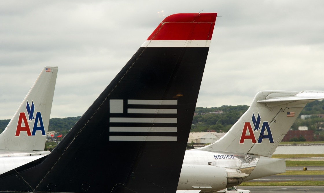 A US Airways plane rests near two American Airlines jets at Ronald Reagan Washington National Airport last year. The combined carrier would be named American Airlines.