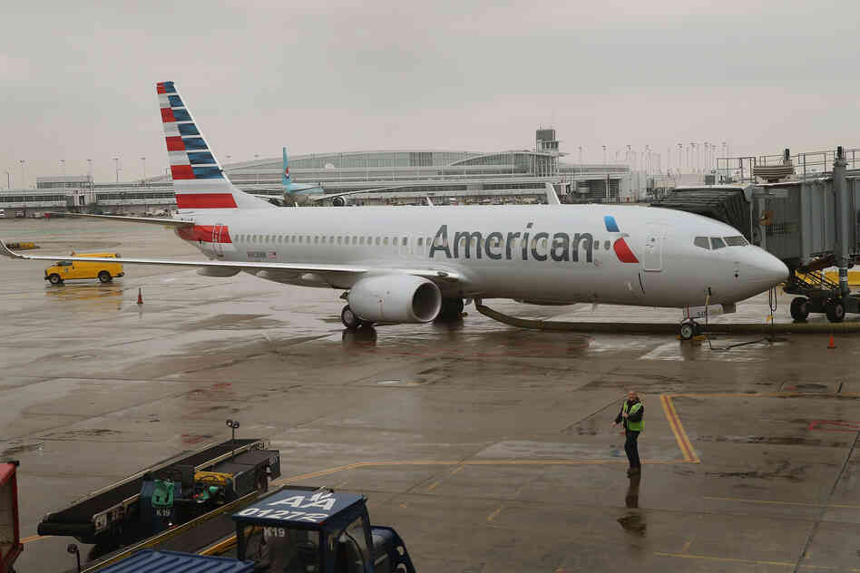 An American Airlines 737-800 aircraft featuring the company's new logo sits at a gate at Chicago's O'Hare International Airport in January. American's merger with US Airways would create the largest U.S. airline.