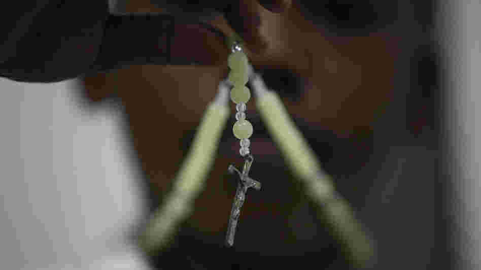A child prays with his rosary at a Catholic church in Lagos, Nigeria, on Monday. In Africa, where the Catholic Church continues to grow, worshippers and clergy greeted Pope Benedict XVI's announcement that he planned to resign with hopes that the continent would see one of its own rise to lead the faithful.