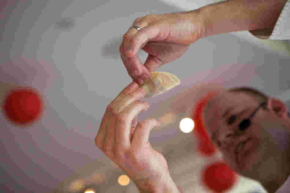 Drewno demonstrates how to properly seal the dumpling casing around the meat filling, a mixture of pork, pork fat and spices.