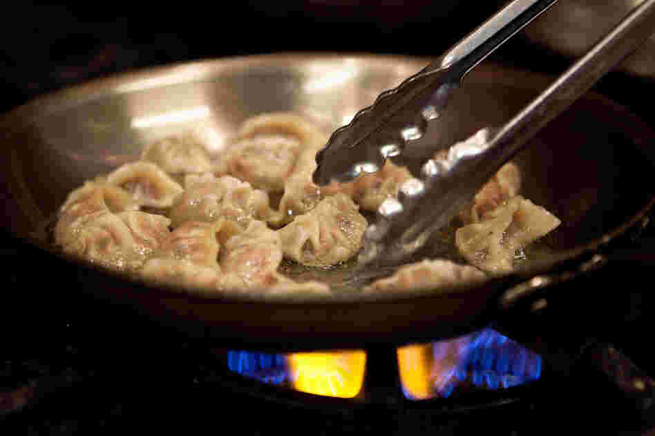 Crinkled on one side, flat on the other, the dumplings are boiled for about 5 minutes until they float, then transferred, flat side down, into a pan of sizzling hot peanut oil. Only one side of the dumpling is fried, and briefly! They may be called potstickers, but that's the last thing you actually want them to do in your pan.