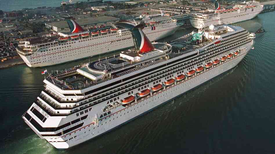 In a photo from 1999, the Carnival Cruise line Carnival Triumph, foreground, arrives in Miami. Measuring 893 feet in length, the ship has been adrift in the Gulf of Mexico for more than 24 hours, after a fire hit its engines.