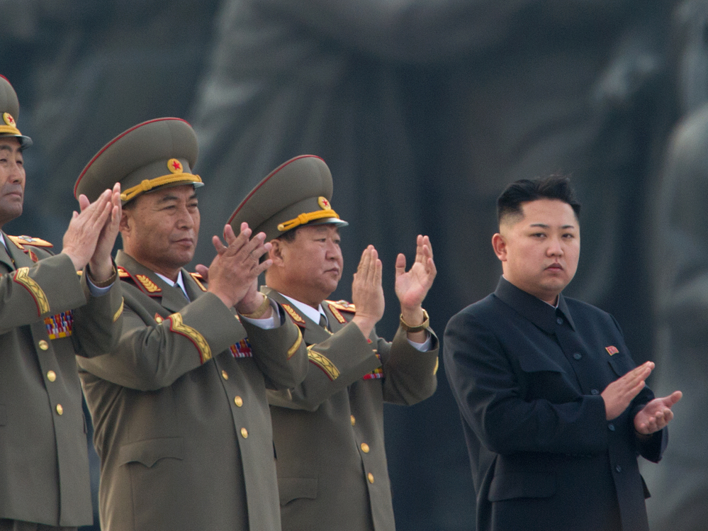 North Korean leader Kim Jong Un (right) claps during a ceremony unveiling statues honoring his grandfather and father, Kim Il Sung and Kim Jong Il, respectively, in Pyongyang last April.