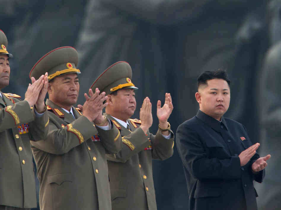 North Korean leader Kim Jong Un (right) claps during a ceremony unveiling statues honoring his grandfather and father, Kim Il Sung and Kim Jong Il, respectively, in Pyongyang last April.