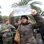 Tunisian soldiers stand guard as a woman holds up a poster featuring opposition leader Chokri Belaid during his funeral procession in a suburb of Tunis on Feb. 8. Belaid's assassination has laid bare the political rifts in post-revolutionary Tunisia.